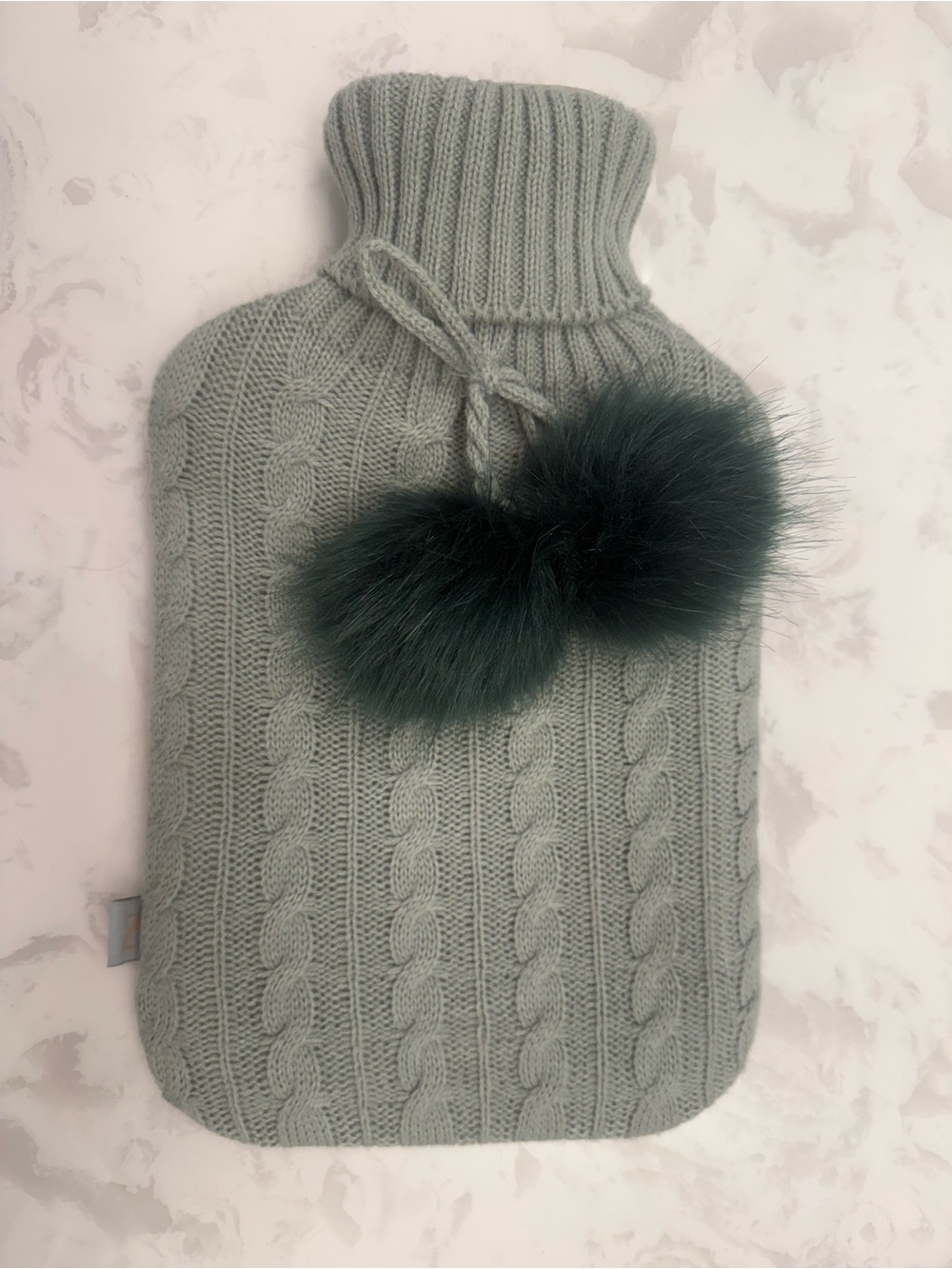 Spells Knit Cable Hot Water Bottle Cover with Faux Fur Pom-Poms - Sage Green.